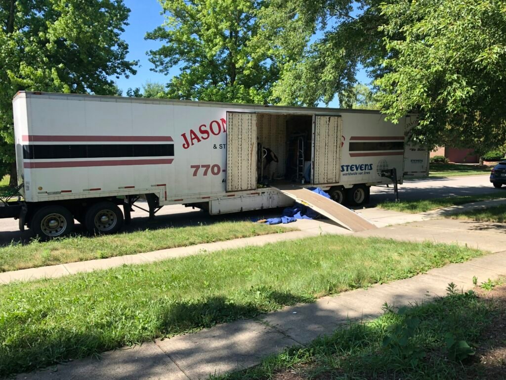 Moving truck parked on a residential street with ramp, ready for loading and unloading, symbolizing professional moving services in North Carolina.